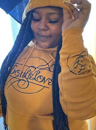 A woman wearing a SoulieLove Collections hoodie