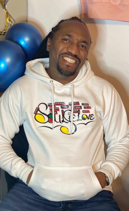A man wearing a SoulieLove Collections hoodie